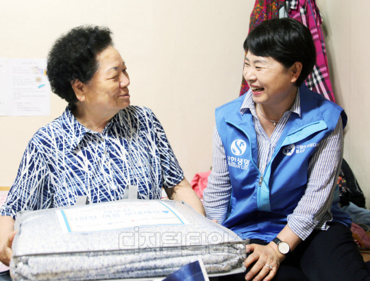 신한생명 소속 설계사 봉사자들이 서울 마포구 도화동에 거주하는 독거어르신 가정을 방문해 여름나기 물품이 담긴 행복 바구니를 전달하고 있다. 신한생명 제공.